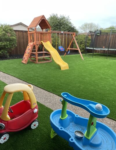 Playscape turf and outdoor structure enhancing backyard living space.