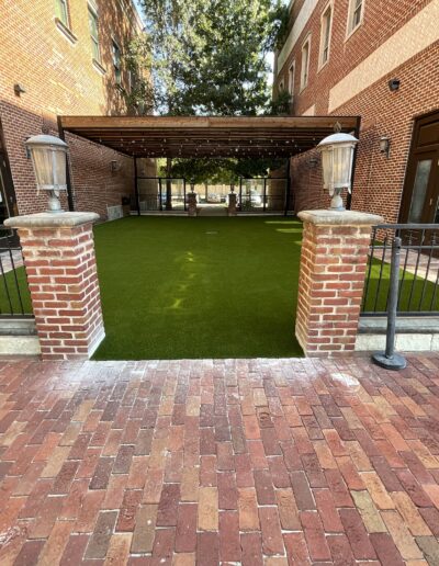 Texas Turf Design outdoor structure with lush artificial turf and brick patio.