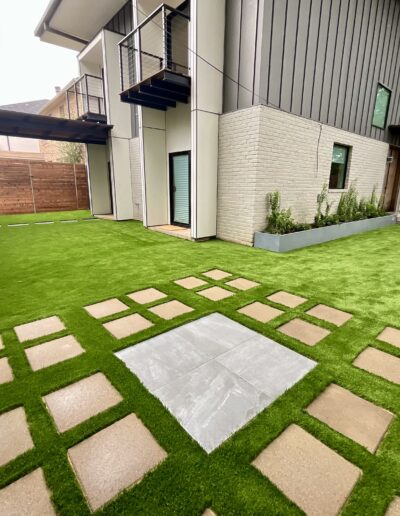 Texas Turf Design outdoor living space with artificial turf and stone pathway.